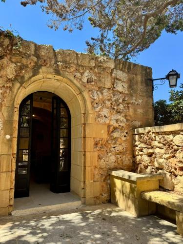 an entrance to a stone building with two doors at Cornucopia Hotel in Xagħra