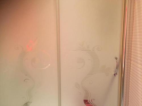 a glass door of a shower with a pattern on it at Masal Otel in Kocaeli