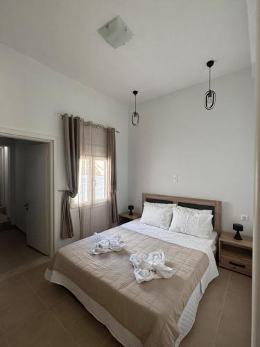 a bedroom with a large bed with towels on it at Nikistratos Cozy Apartment in Néa Alikarnassós