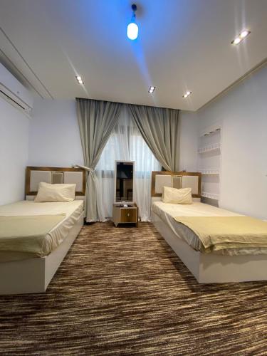 a bedroom with two beds and a window at Royal Suite Hotel - Nasr City, Cairo in Cairo