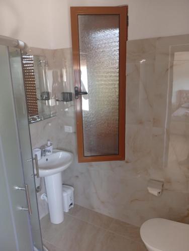 a bathroom with a sink and a shower with a mirror at Villa Kalaj in Baks-Rrjoll