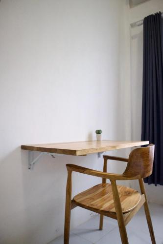a wooden desk with a wooden chair underneath it at Isirela in Kuta Lombok