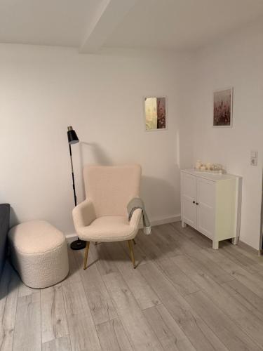 a living room with a chair and a dresser at Ferienwohnung Wülfrath in Wülfrath