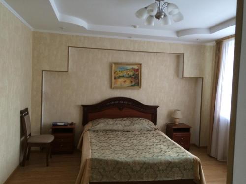 a bedroom with a bed and a lamp at Hotel VIARDO on Timiryazeva 17 in Almetyevsk