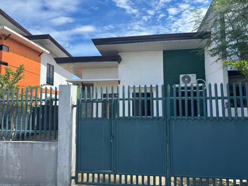 a blue gate in front of a house at Family Island House in Casa Verde Mati City in Mati