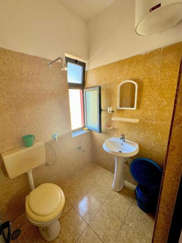 a bathroom with a toilet and a sink at Hotel Martini in Velipojë