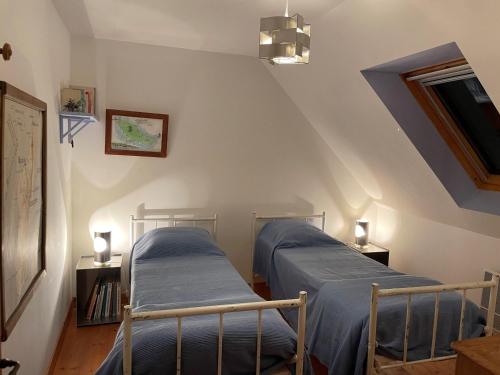 Cette chambre mansardée comprend 2 lits jumeaux. dans l'établissement Grande Maison avec Jardin Près de la Plage - 4 Chambres, WIFI et Cheminée - FR-1-418-5, à Locmaria
