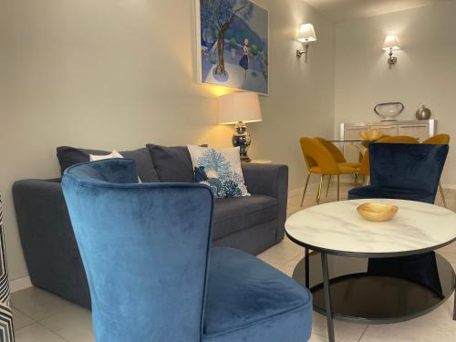 a living room with a couch and a table and chairs at Hotel Le Fouquet's in Cannes