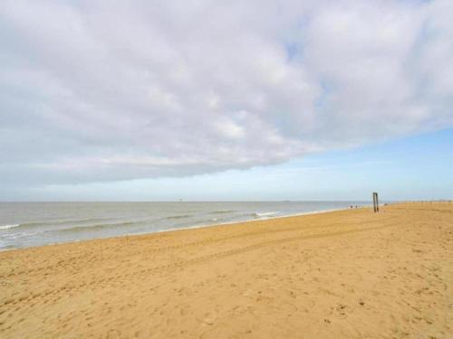 a sandy beach with the ocean on a cloudy day at Apartment in Maldegem with Scenic Terrace in Maldegem