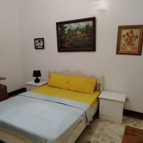 a bedroom with a bed and a painting on the wall at White & Yellow Castle Hotel and Resort in Calatagan