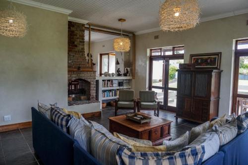a living room with blue couches and a fireplace at A Hilltop Country Retreat in Swellendam