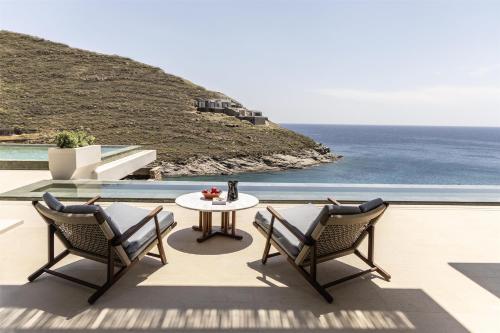 a patio with a table and chairs and the ocean at One&Only Kéa Island in Pisses