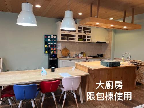 a kitchen with a counter with chairs around it at 騎馬打仗民宿 in Yilan City