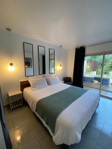 une chambre avec un grand lit et une grande fenêtre dans l'établissement Villa COSA, Gîte Spa privatif -5 min- Sarlat, à Vitrac