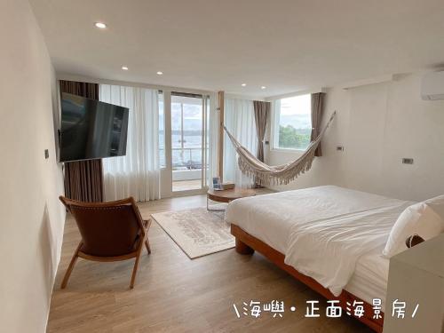 a bedroom with a bed and a tv and a hammock at QBE 民宿 南灣館 QBE Nanwan in Nanwan