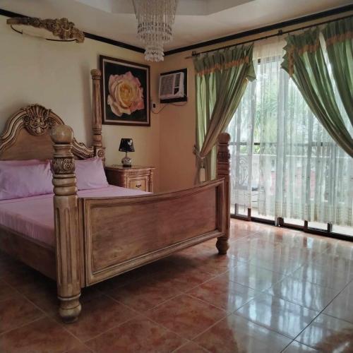 a bedroom with a bed and a large window at White & Yellow Castle Hotel and Resort in Calatagan