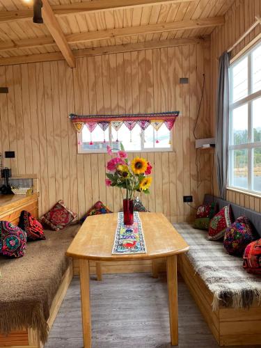 a room with a table with a vase of flowers on it at CABAÑA ORO RAYADO PUERTO MONtt in Puerto Montt