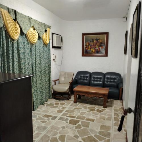 a living room with a couch and a chair at White & Yellow Castle Hotel and Resort in Calatagan