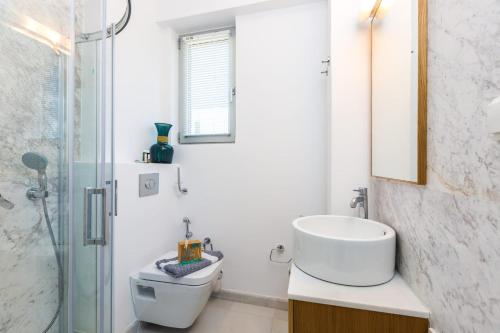 a bathroom with a toilet and a sink and a shower at Extraordinary Rethymno Villa Villa Hantengu 3 Bedrooms Beach Front Private Outdoor Swimming Pool And Hot Tub Pigianos Kampos in Pigianos Kampos