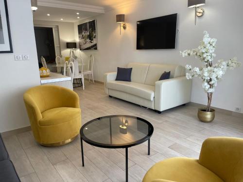a living room with a couch and a table and chairs at Hotel Le Fouquet's in Cannes
