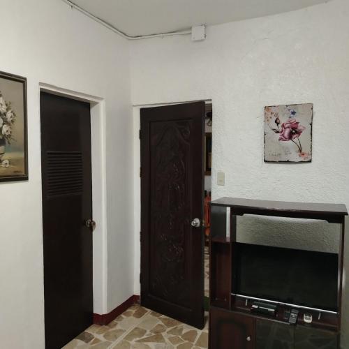 a living room with a tv and a door at White & Yellow Castle Hotel and Resort in Calatagan