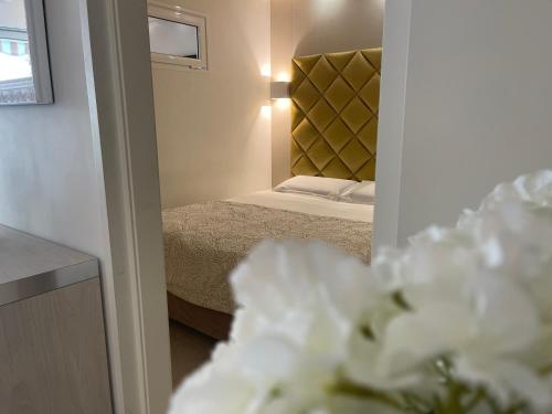 a bedroom with a bed and a vase of flowers at Hotel Le Fouquet's in Cannes