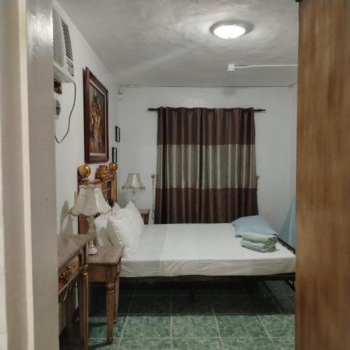a bedroom with a bed and a window at White & Yellow Castle Hotel and Resort in Calatagan