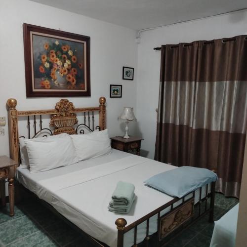 a bedroom with a bed and a painting on the wall at White & Yellow Castle Hotel and Resort in Calatagan