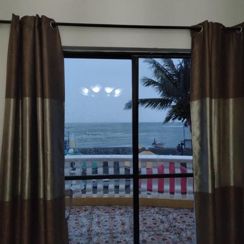 a view of the ocean from a room with a window at White & Yellow Castle Hotel and Resort in Calatagan