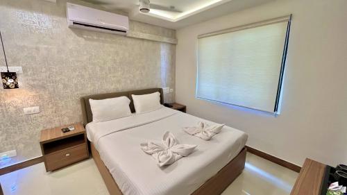 a bedroom with a bed with flowers on it at Hotel Pearl Palace in Cochin