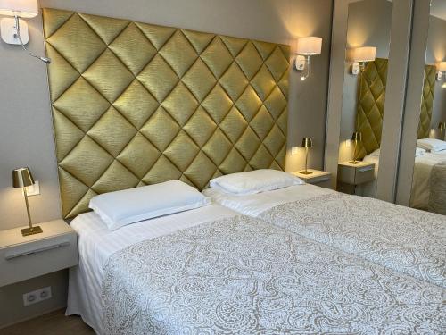 a bedroom with a large bed and a large mirror at Hotel Le Fouquet's in Cannes