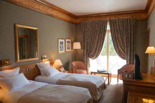 a hotel room with two beds and a mirror at Le Grand Hôtel - Domaine De Divonne in Divonne-les-Bains