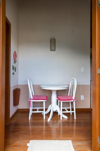 a white table with two chairs and a table with a table at Pousada Bela Aurora in Venda Nova do Imigrante