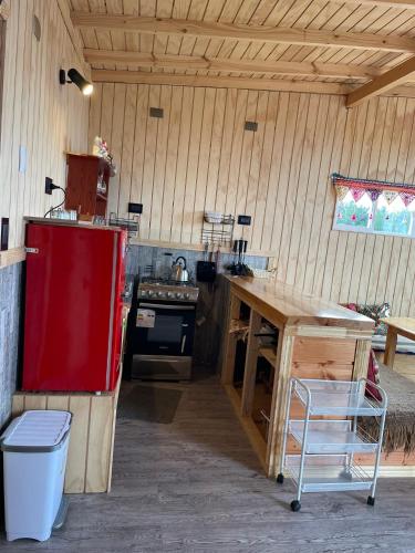 a kitchen with a red refrigerator and a wooden table at CABAÑA ORO RAYADO PUERTO MONtt in Puerto Montt