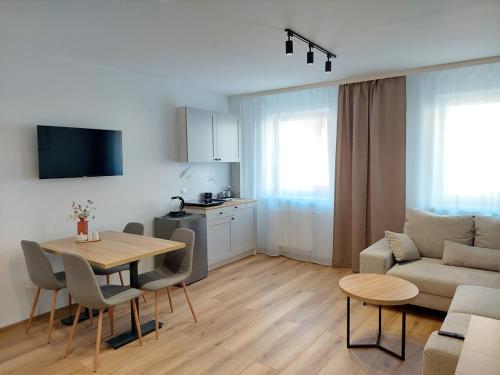 un soggiorno con un tavolo e un divano di Apartament dwuosobowy A07 w Welle a Grzybowo