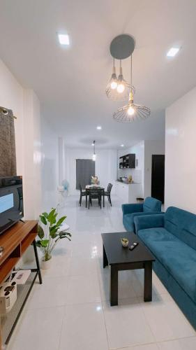 a living room with a blue couch and a table at 2 Storey Family House in Casa Verde Mati City in Mati