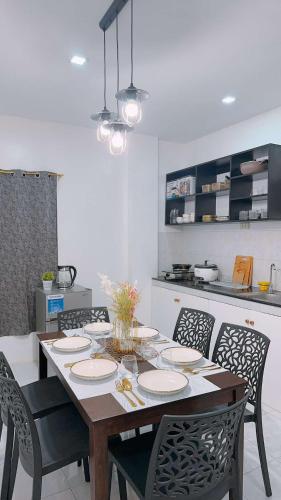 a dining room table with chairs and a kitchen at 2 Storey Family House in Casa Verde Mati City in Mati