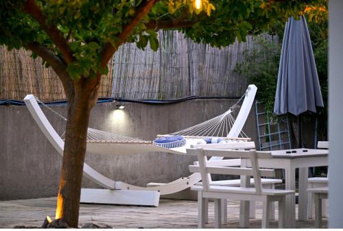 a hammock and chairs next to a tree and an umbrella at Anchor Villa in Troulos