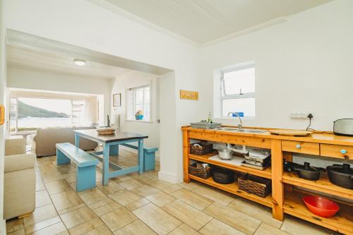 a kitchen with a counter and a table in a room at Silver Spray Beach Accommodation in Victoria Bay