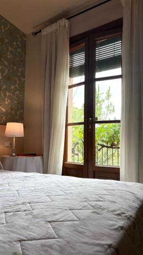 a bedroom with a large bed and a window at Hotel Antiga in Calafell