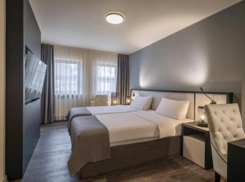 a hotel room with a large bed and a television at Hotel Innsento - Health Campus Passau in Passau
