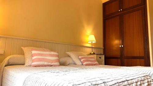a bedroom with a bed with pink and white pillows at Hotel Antiga in Calafell