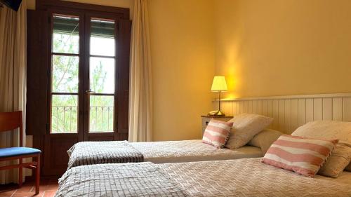 a bedroom with a bed with two pillows and a window at Hotel Antiga in Calafell