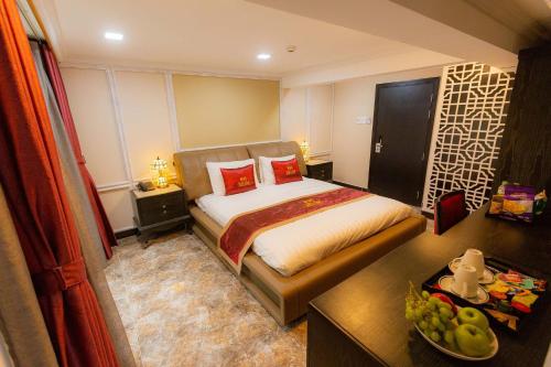 a bedroom with a bed and a table with a bowl of fruit at Belvilla Near Tan Son Nhat International Airport - Formerly Havana Hotel in Ho Chi Minh City