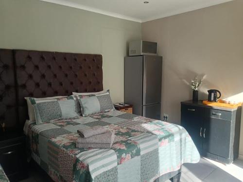 a bedroom with a bed with a quilt on it at Home Sweet Home in Polokwane
