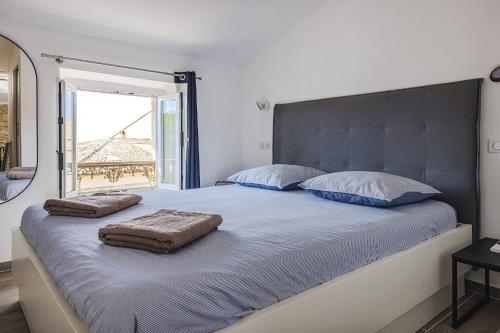 une chambre avec un grand lit avec deux oreillers dessus dans l'établissement Maison Liberation - Centre Tourrettes sur Loup, à Tourrettes-sur-Loup