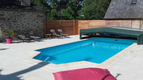 a swimming pool with a green cover on a patio at Les Roulottes de la Baronnie in Saint Malo