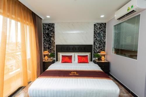a bedroom with a large bed with red pillows at Belvilla Near Tan Son Nhat International Airport - Formerly Havana Hotel in Ho Chi Minh City