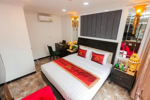 a bedroom with a large white bed with red pillows at Belvilla Near Tan Son Nhat International Airport - Formerly Havana Hotel in Ho Chi Minh City