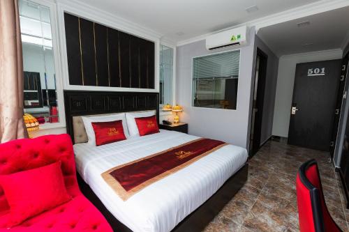 a bedroom with a large bed and a red couch at Belvilla Near Tan Son Nhat International Airport - Formerly Havana Hotel in Ho Chi Minh City